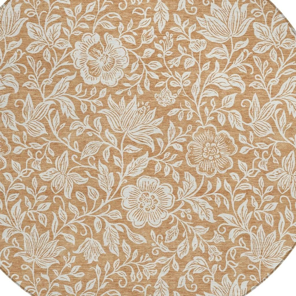 Round area rug close-up, copper-brown background with ivory flower-and-leaf pattern