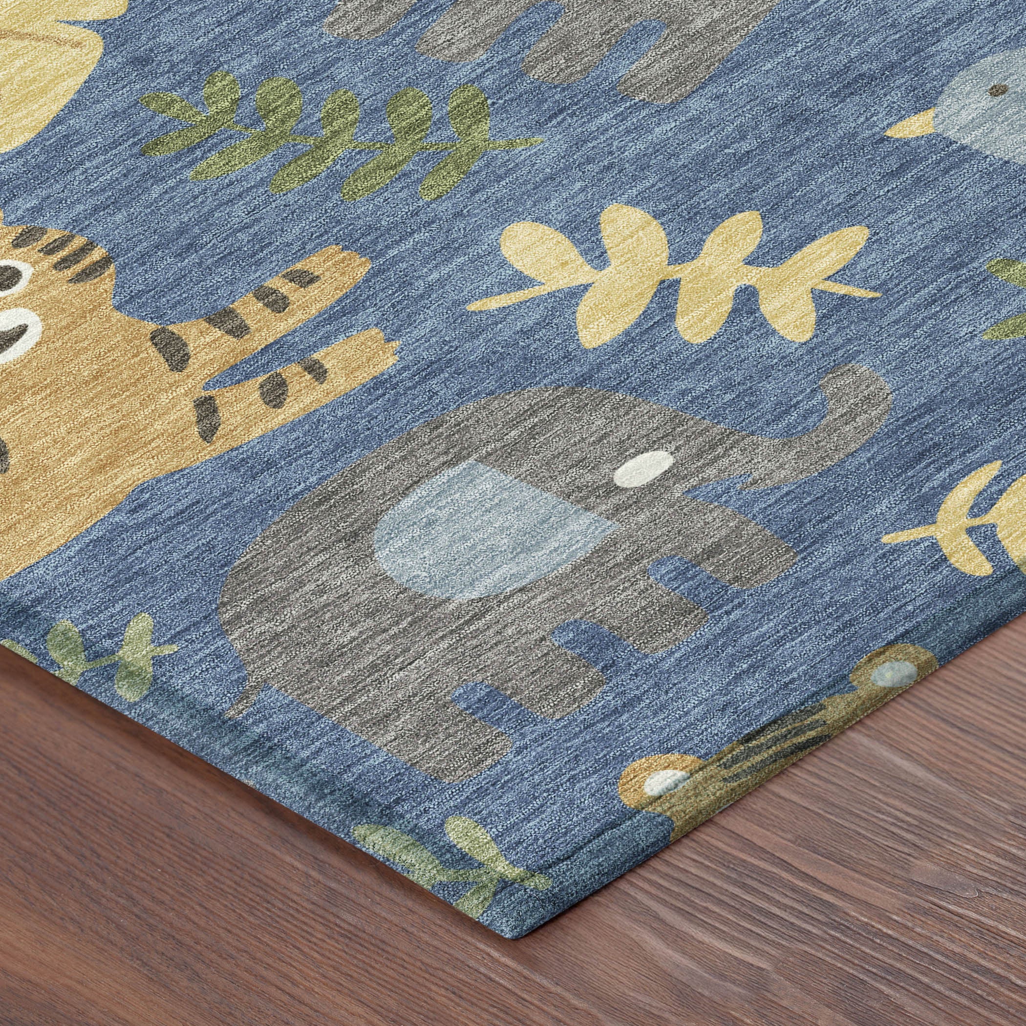 Abstract area rug with blue field and beige, green, and gray animal shapes; corner view.