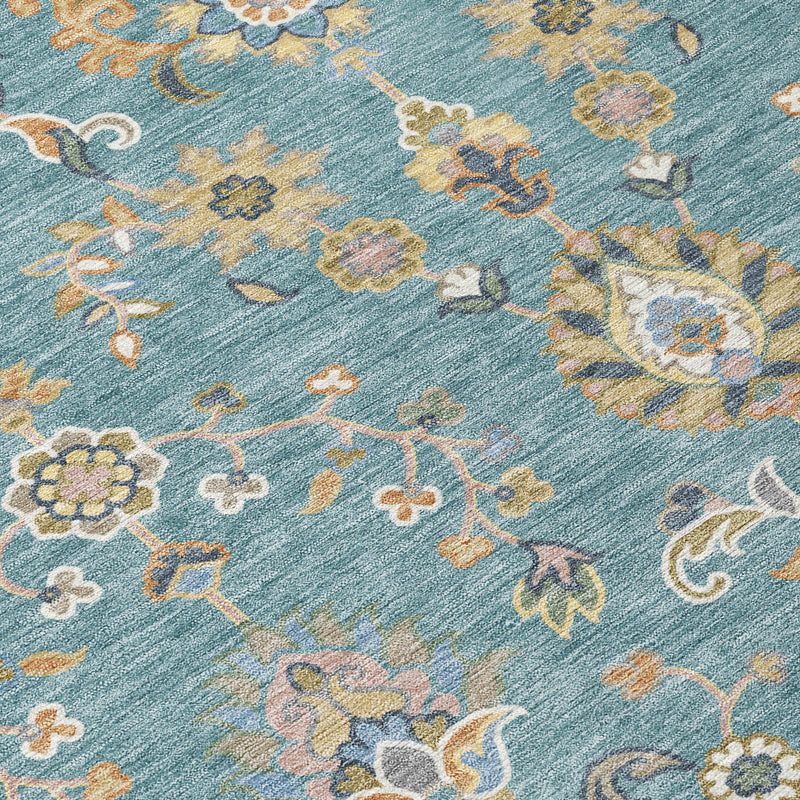 Teal blue rug close-up with taupe and cream scrolling florals and dotted accents