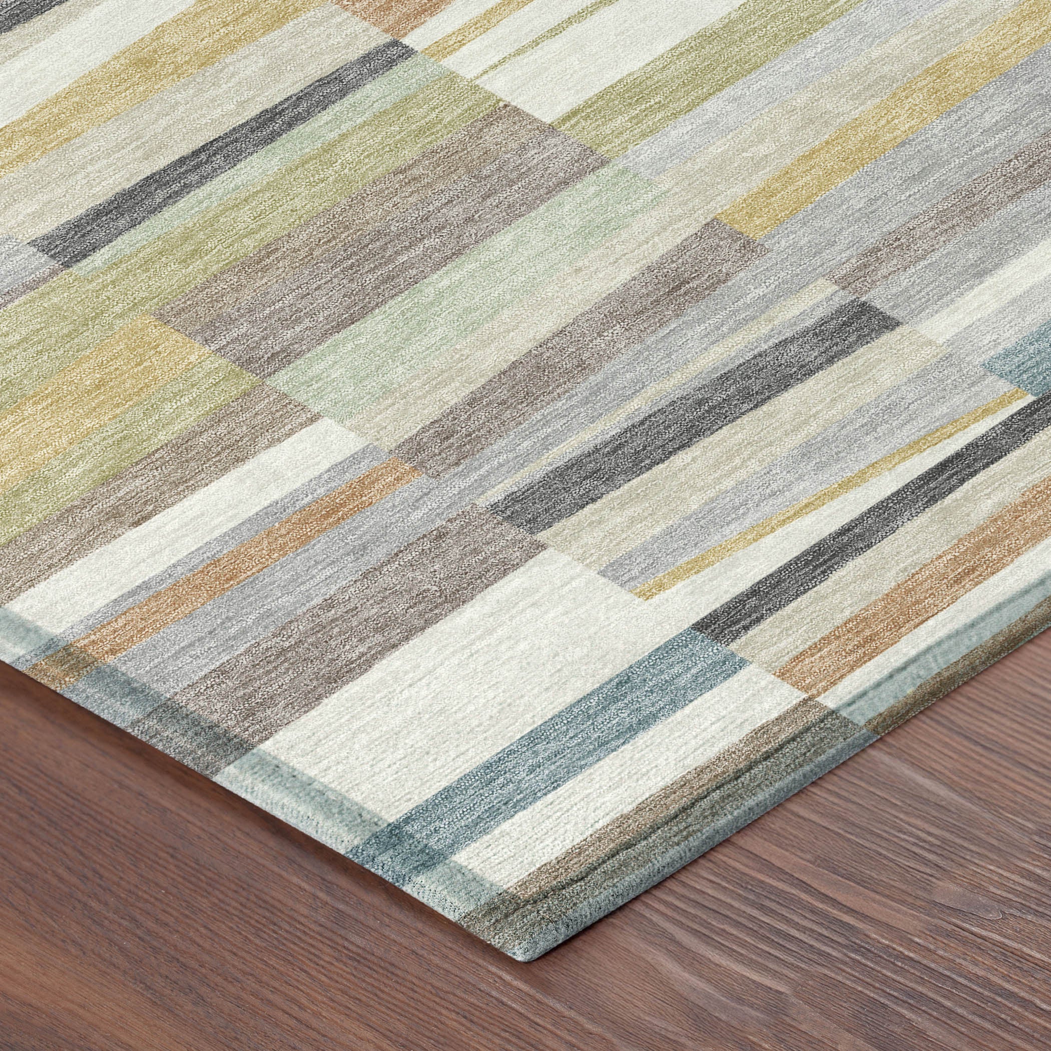 Corner view of striped patchwork area rug with cream, teal, green, gray, and tan tones