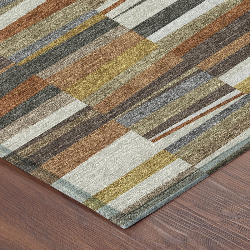 Area rug corner view with layered stripe blocks in gray, tan, olive, and rust