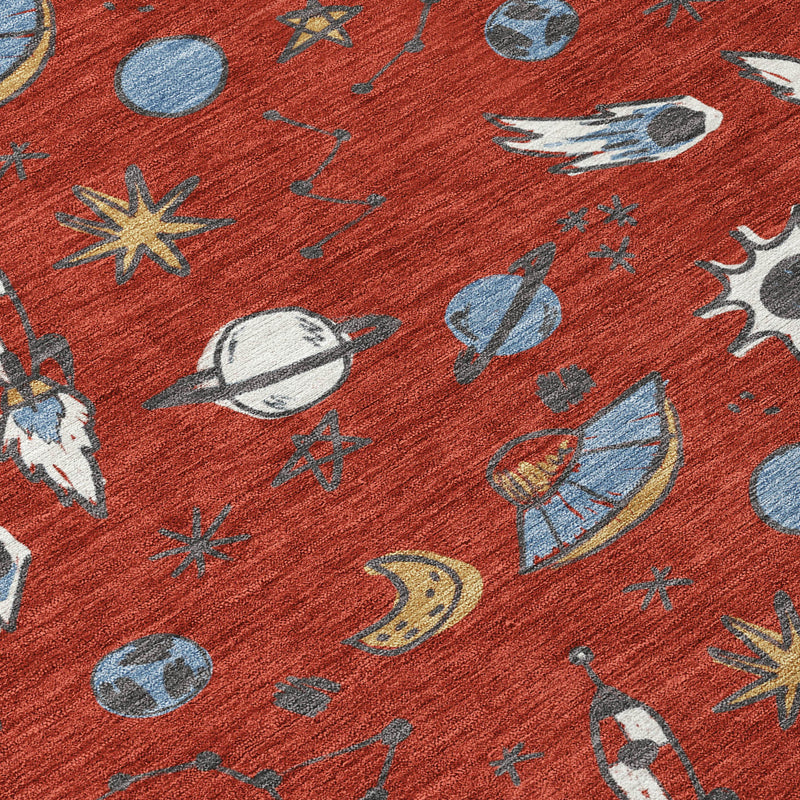 Close-up of red area rug fabric with blue planet, sun, rocket, and star icons