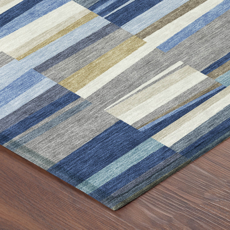 Area rug corner view with multicolor striped square blocks in blues, grays, cream, and tan
