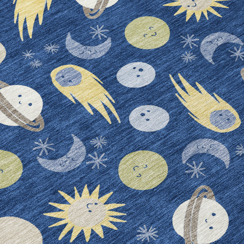 Navy blue area rug with planets, moons, comets, and yellow sunburst shapes; close-up.
