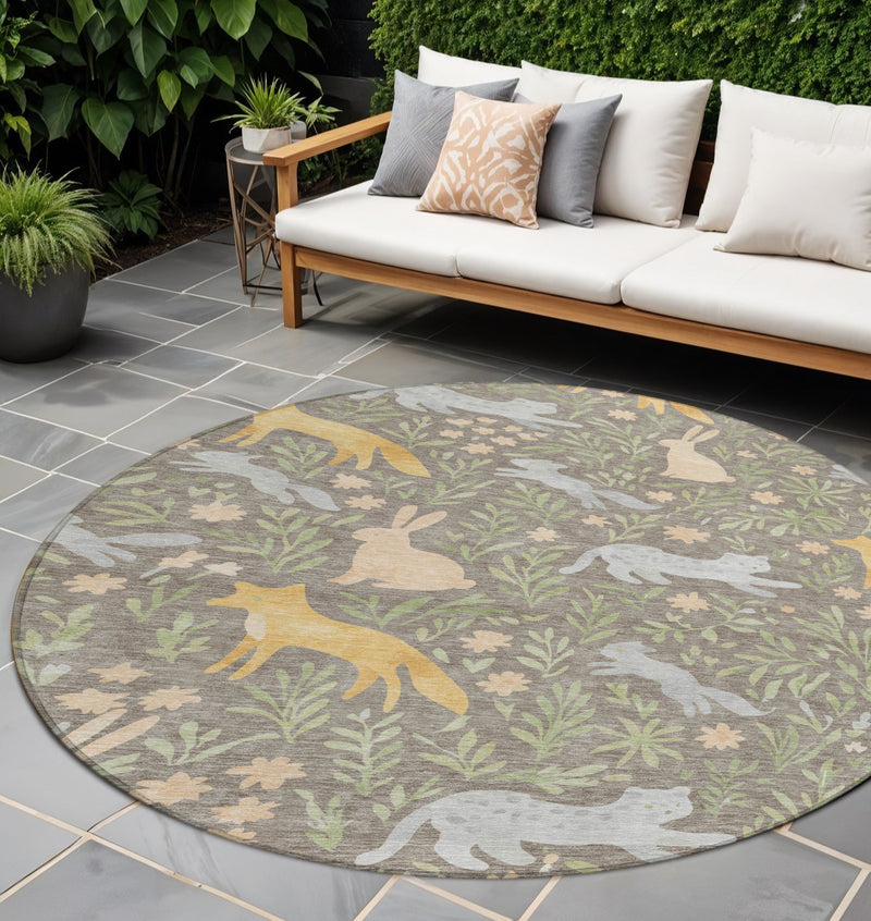 Round forest animal and botanical leaf area rug in green, tan, and gray tones