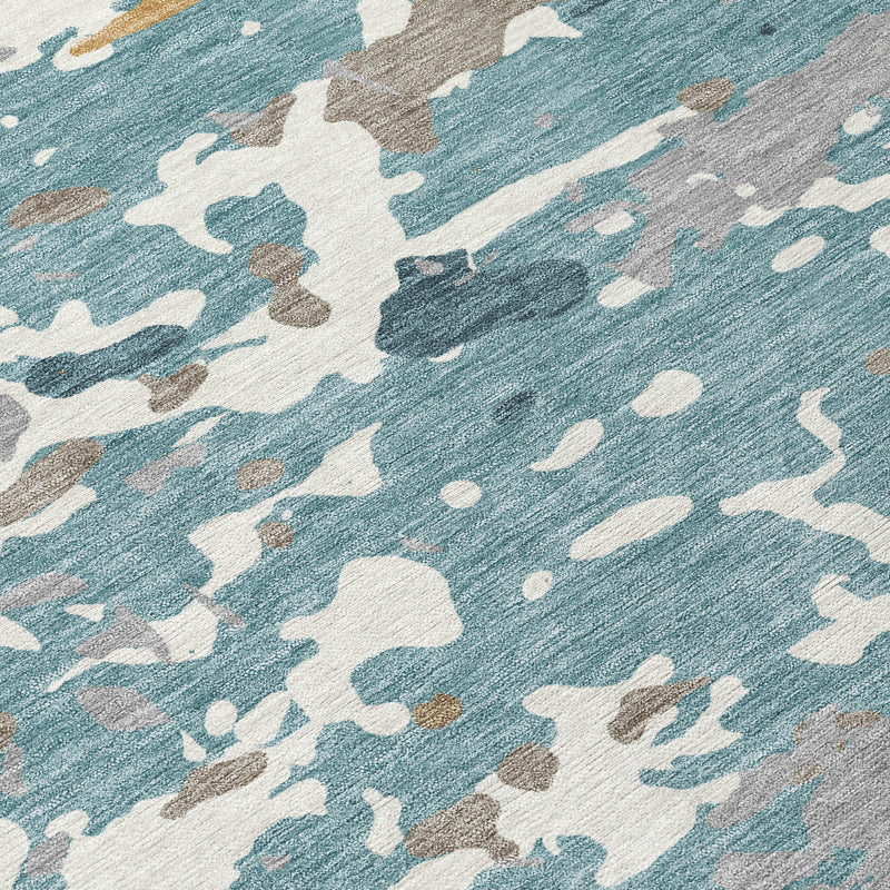 Abstract rug close-up in teal blue, ivory, and tan with speckled print