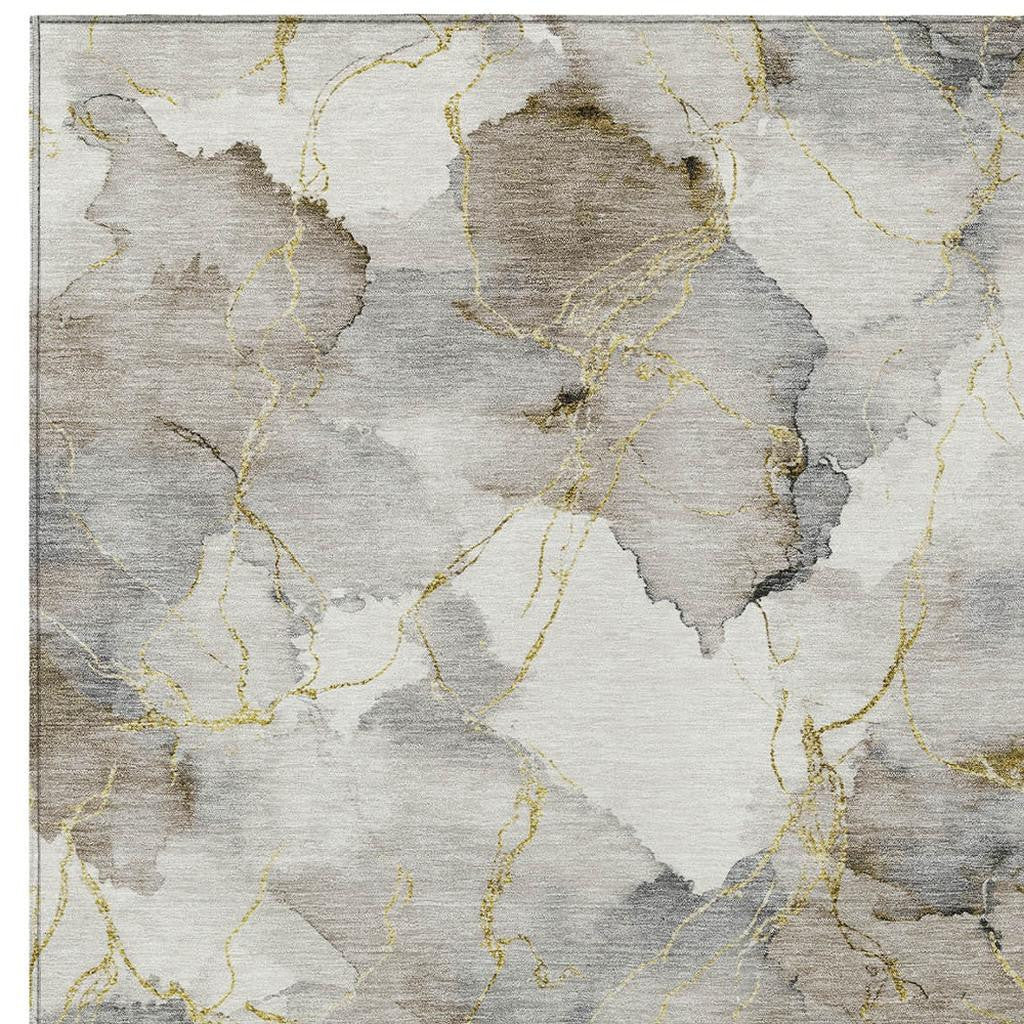 Abstract gray and beige area rug with gold accents, modern design, soft synthetic material, perfect for contemporary interiors.