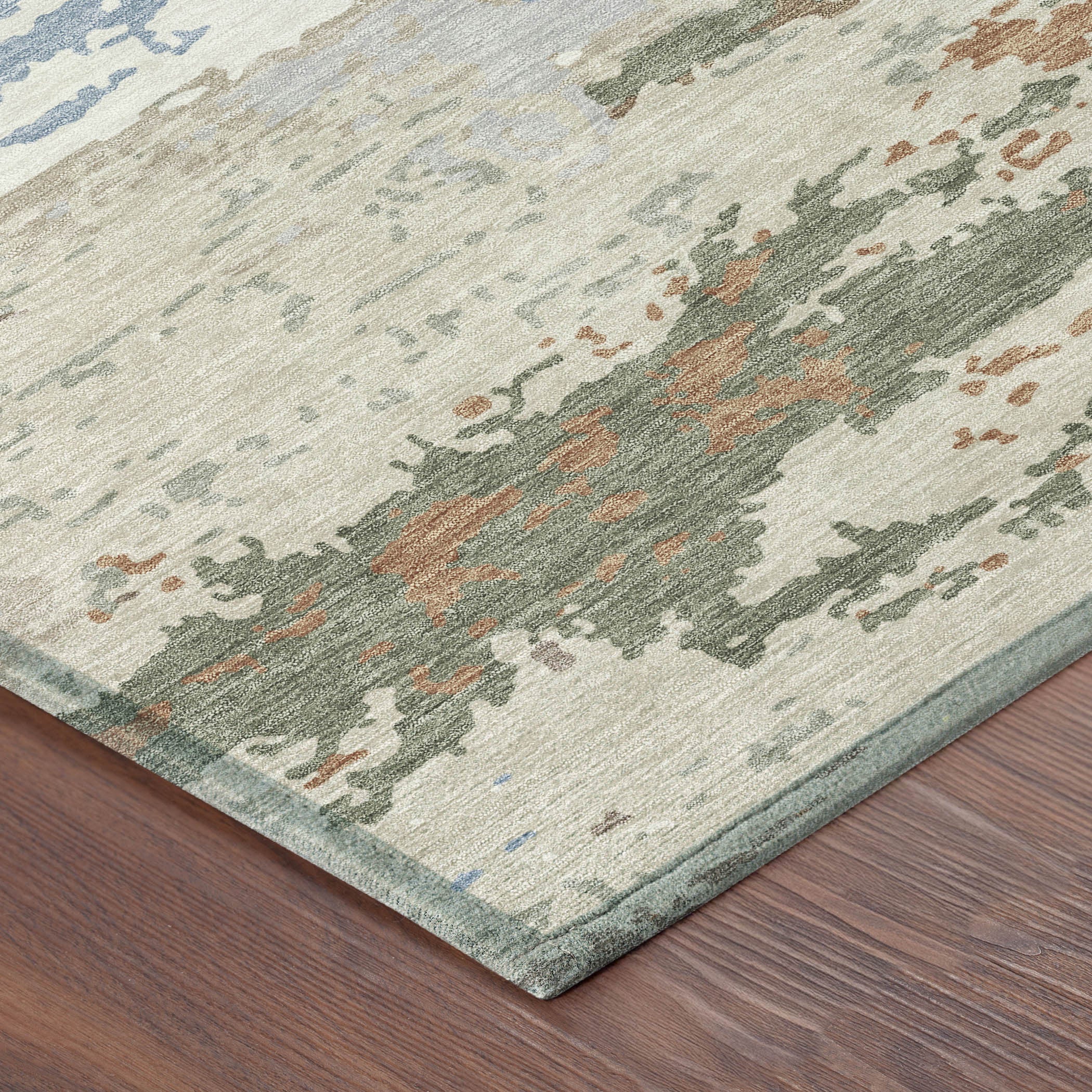 Textured area rug in muted greens, blues, and browns, featuring a modern abstract design, perfect for contemporary decor.