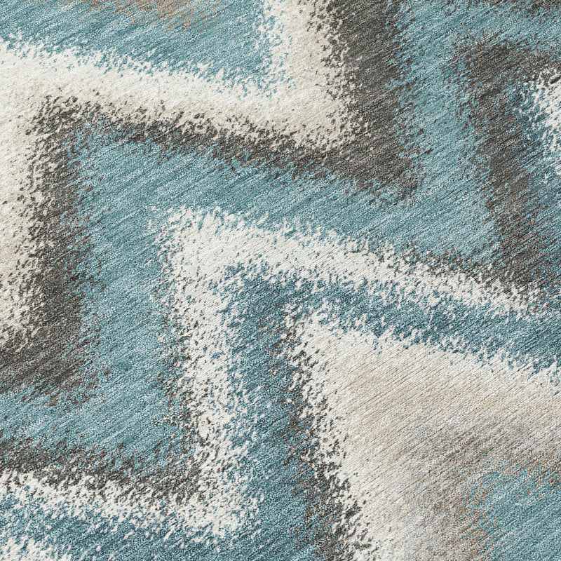 Round area rug close-up with teal, cream, and charcoal abstract wash texture