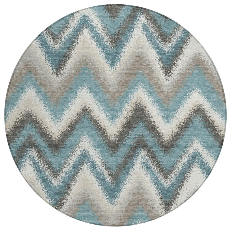 Round area rug with layered teal zigzag pattern on light cream background