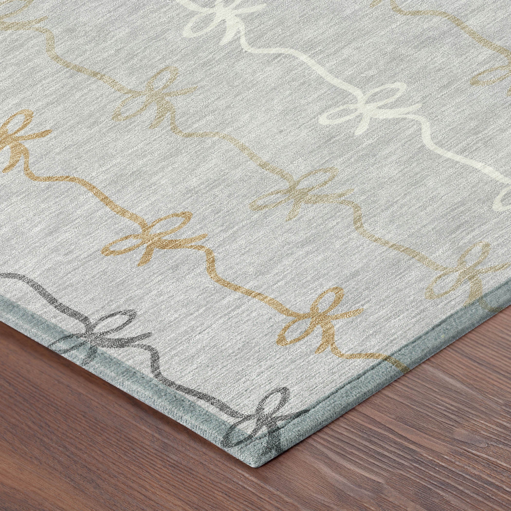 Gray area rug with a ribbon pattern in gold, cream, and charcoal, perfect for stylish home decor.