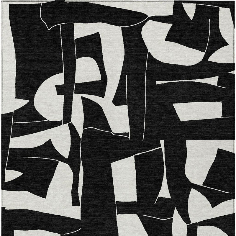 Geometric area rug in black with ivory abstract shapes and lines, top view close-up
