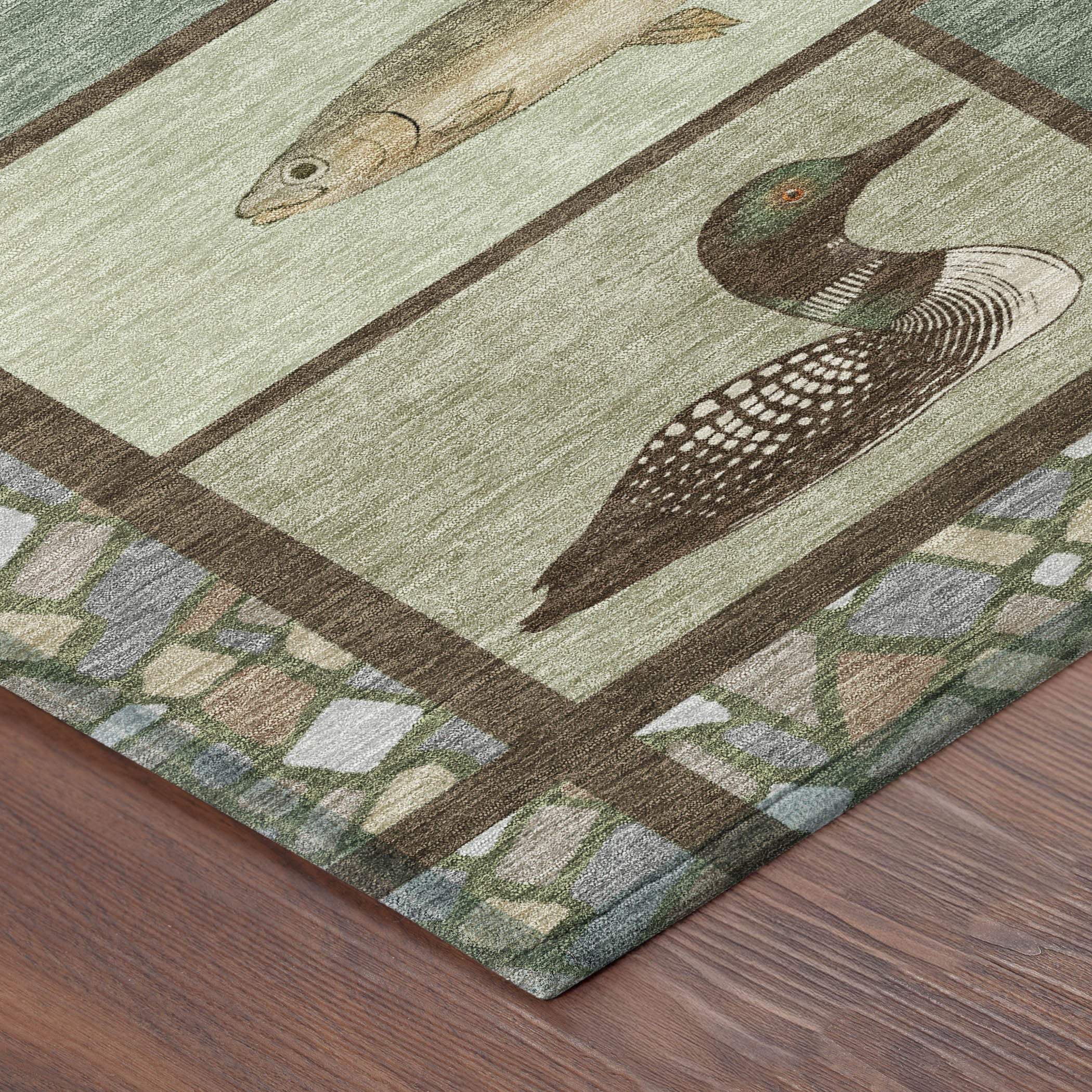 Artisan green area rug featuring trout and loon designs, with a natural stone border, perfect for rustic decor.