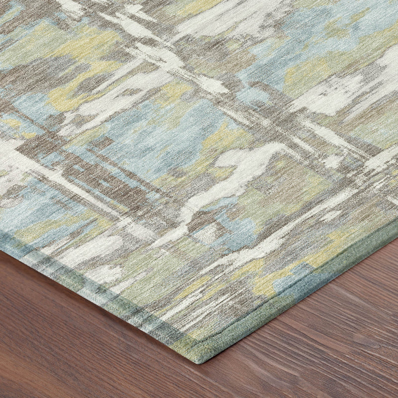 Abstract area rug corner on wood floor with muted green, blue, and ivory distressed design