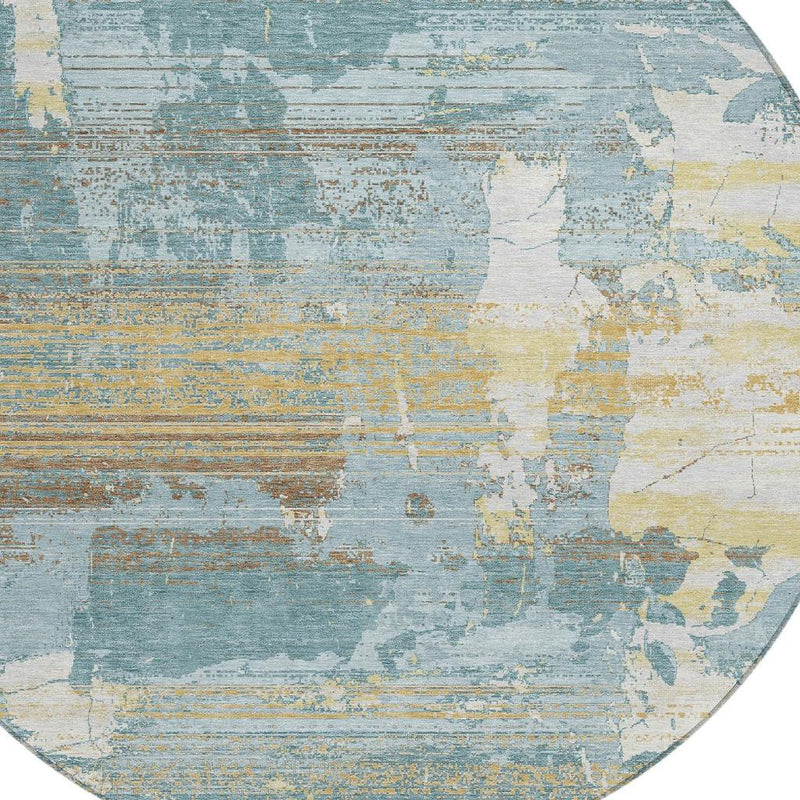 Round abstract area rug showing teal blue and pale yellow faded block pattern