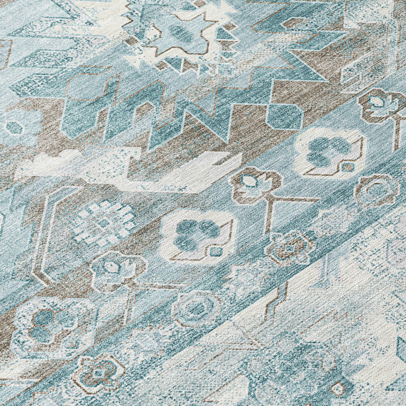 Teal and silver patterned area rug with ornate motifs and distressed texture.