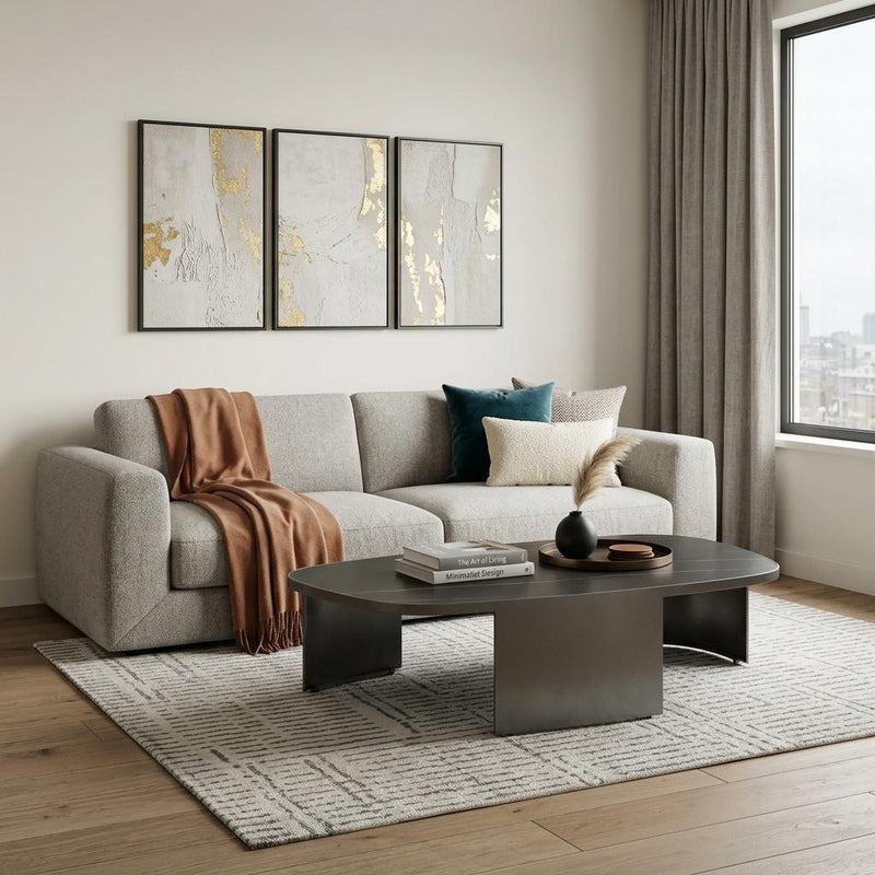 Oval black ceramic coffee table with gold veining and dark gray steel pedestal base