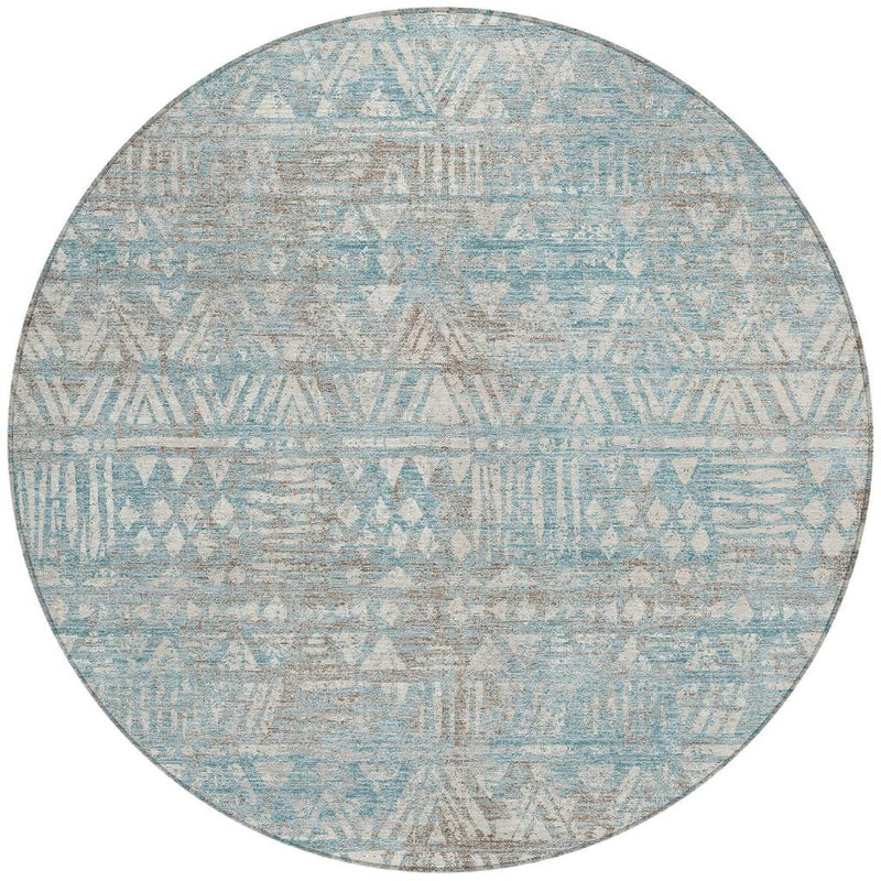 Round area rug with teal-blue and pewter geometric pattern, distressed and textured
