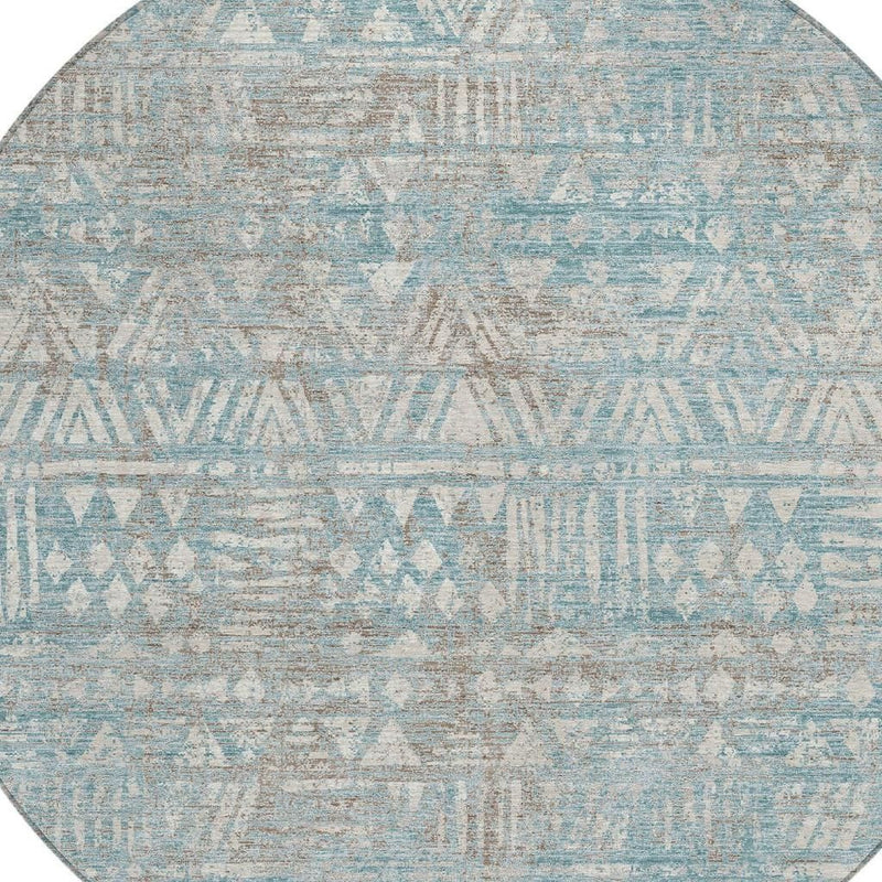 Round area rug detail: teal-blue geometric rows on pewter distressed background