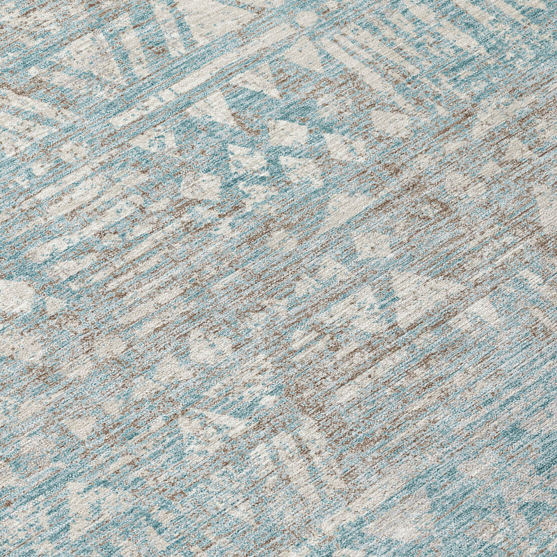 Area rug texture close-up with teal-blue and pewter distressed geometric pattern