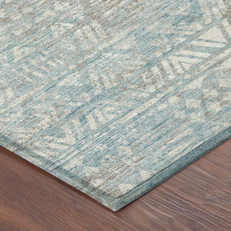 Round area rug corner showing teal-blue and pewter geometric weave texture
