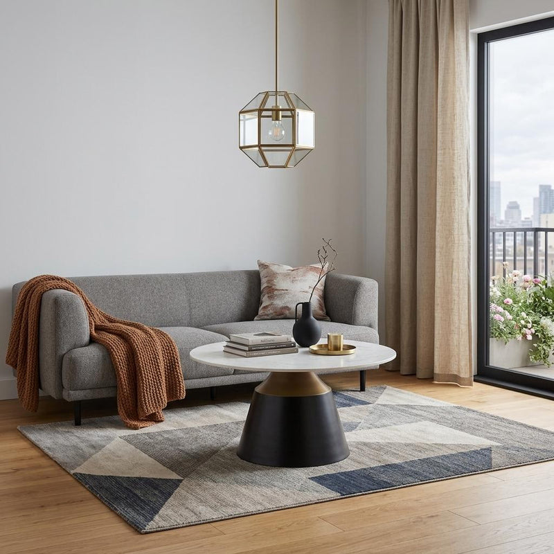 Round pedestal coffee table with white faux marble top, black steel base, gold accent