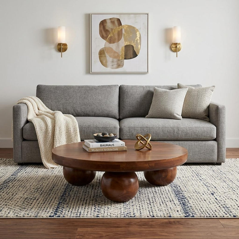 Round chestnut solid-wood coffee table with sculpted pedestal legs.
