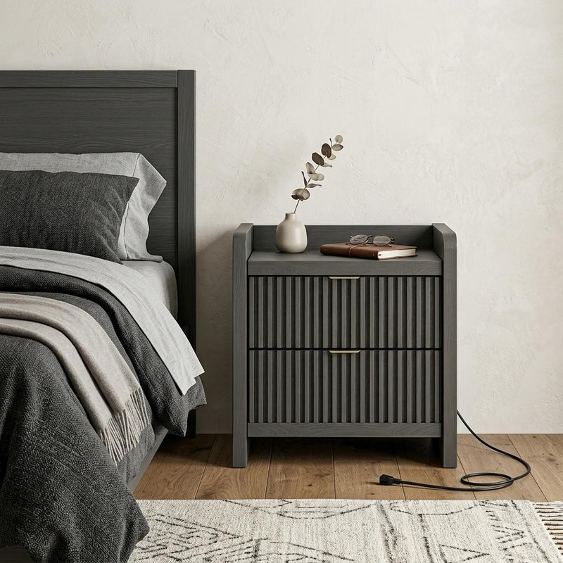 Black nightstand with ribbed front drawer and open top shelf beside bed