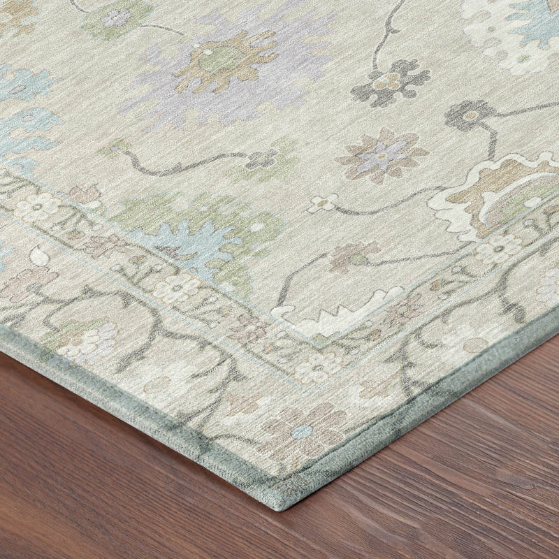 Corner view of light gray area rug with pale blue and green floral medallions