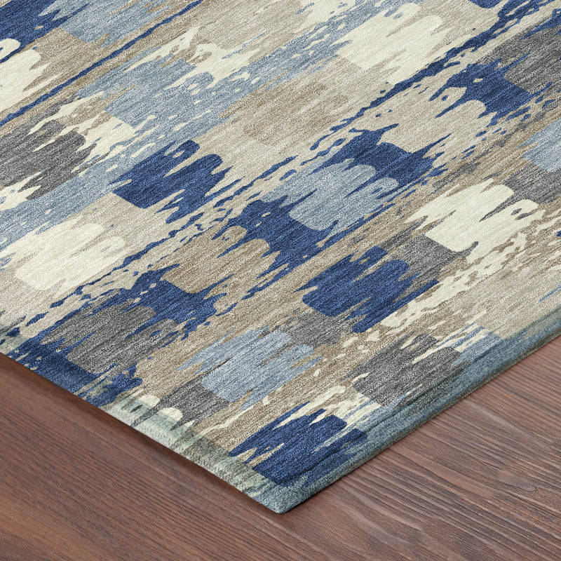 Corner close-up of abstract area rug in navy blue and gray on a cream base.