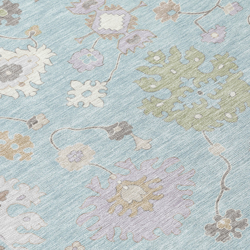 Close-up of sky blue indoor outdoor rug with beige, gray, and pastel motif pattern