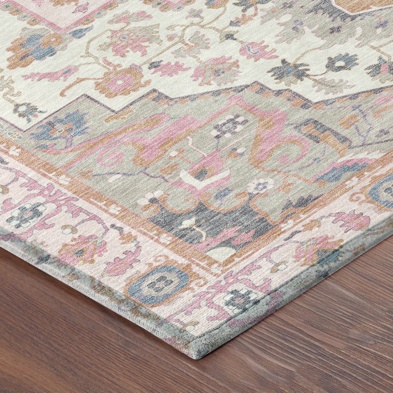 Pink and gray oriental area rug corner detail with faded pattern and lightly textured pile.