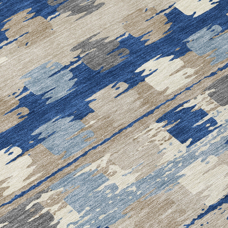 Close-up abstract washable area rug with blue, light blue, and beige paint-like blocks.