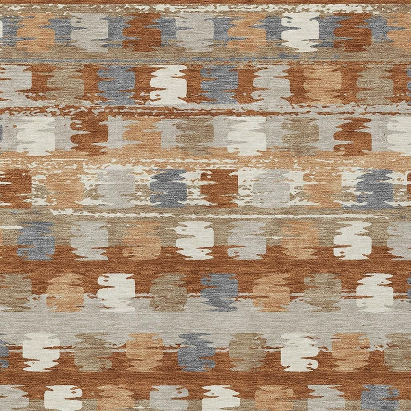 Abstract area rug pattern detail in rust orange, beige, and blue-gray tones.