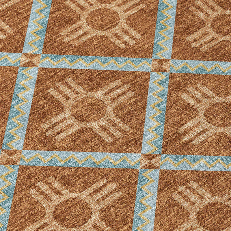 Geometric area rug close-up: brown panels with tan motifs and light blue zigzag border