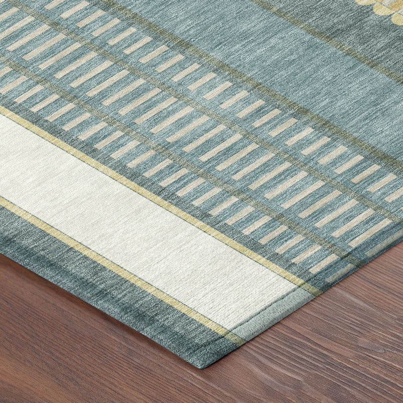 Corner view of teal area rug with gold trim and repeating dash pattern