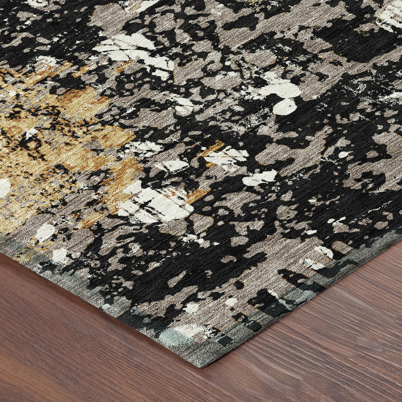 Corner view of round abstract area rug with black, white and gold textured speckle design