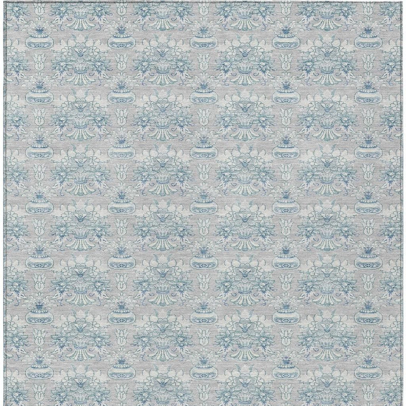 Indoor outdoor area rug, full view, muted silver-gray background with blue floral motifs