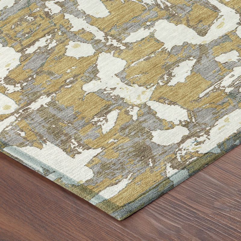 Gold and ivory abstract area rug with worn distressed pattern and visible border