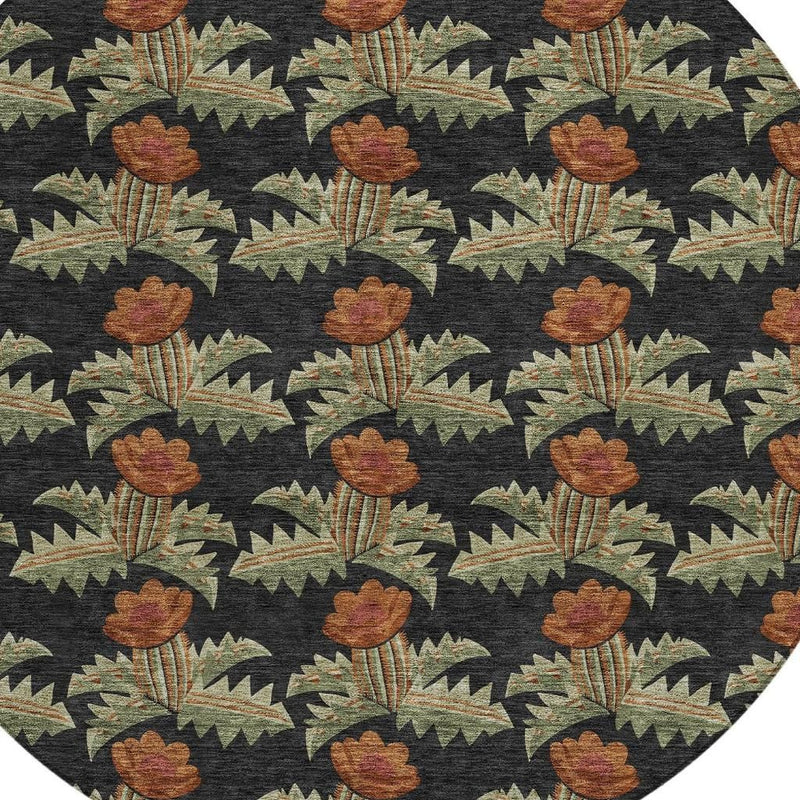 Close-up of round area rug pattern: black background with brown-orange florals and green leaves