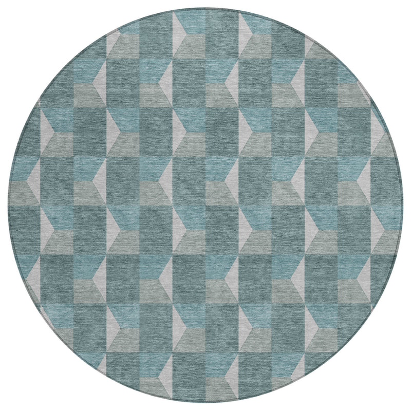 Round rug with teal, gray, and beige geometric pattern on textured fabric
