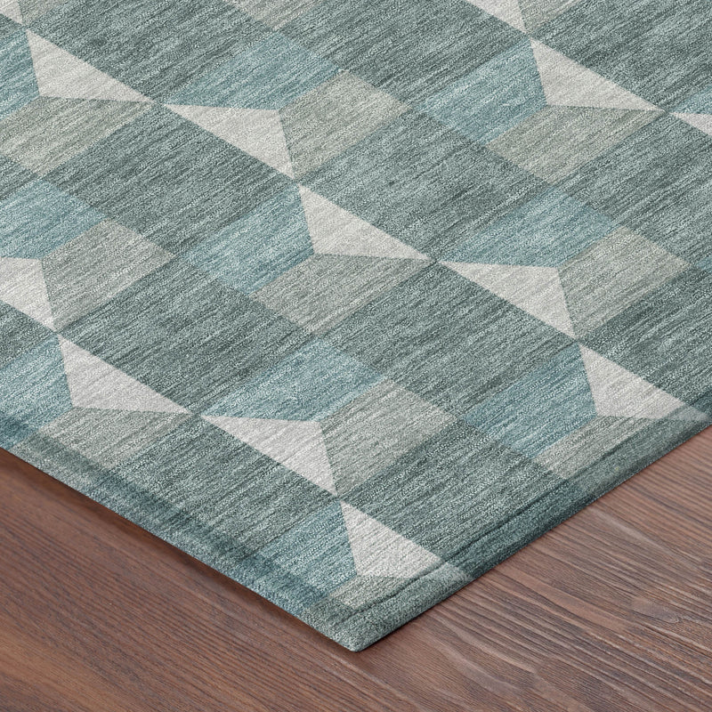 Corner view of round rug showing teal/gray geometric weave and textured pile