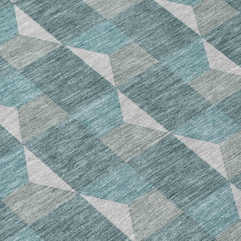 Close-up of round rug fabric with teal and gray textured geometric pattern
