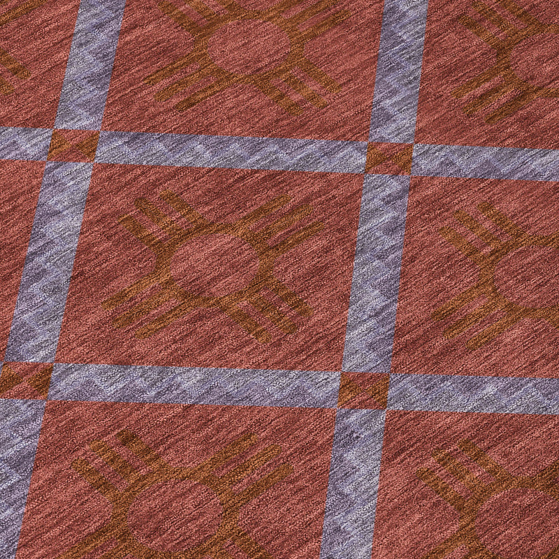 Geometric pattern detail on maroon area rug with light gray grid stripes
