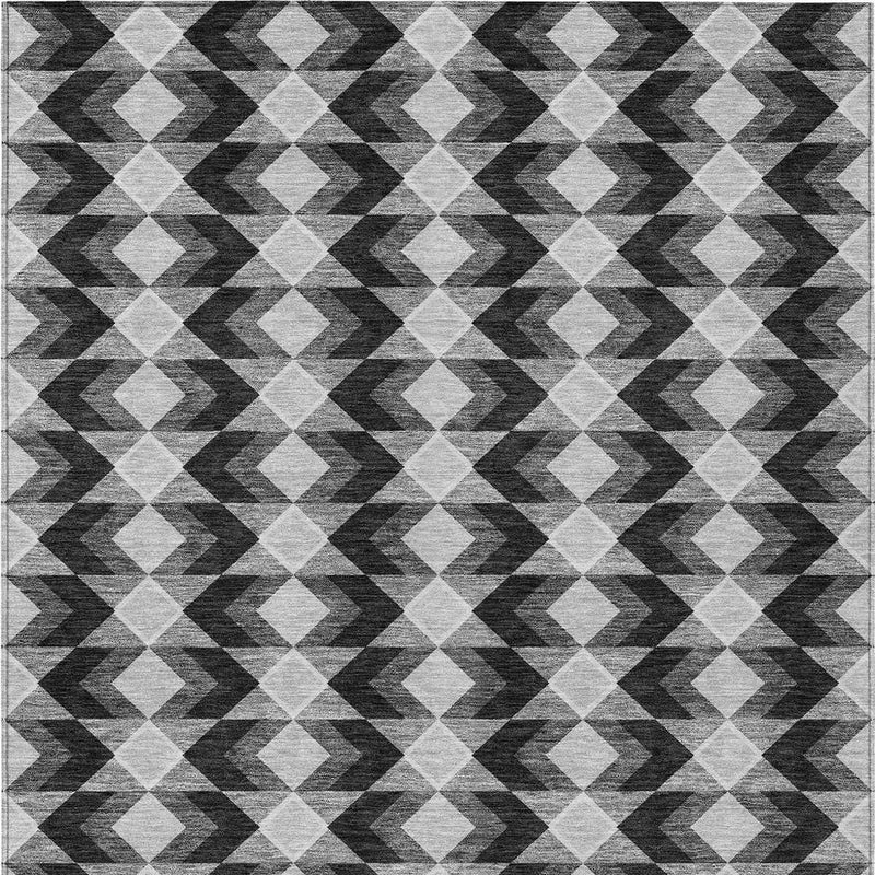 Close view of black, gray, and white geometric area rug with diamond and chevron shapes