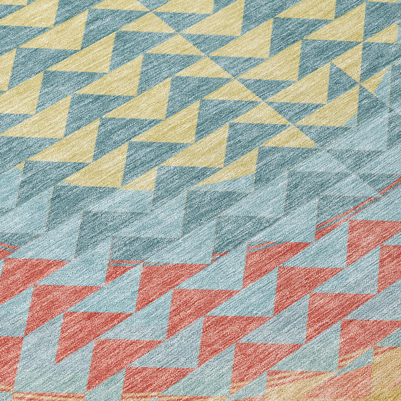 Teal blue geometric area rug with crisscross chevron blocks in yellow, coral, and gray