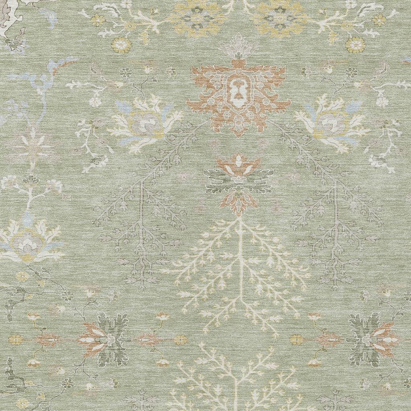 Close-up of green area rug with ivory foliage and orange medallion motifs