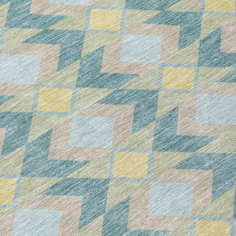 Close-up of teal blue geometric area rug with light cream and yellow accents