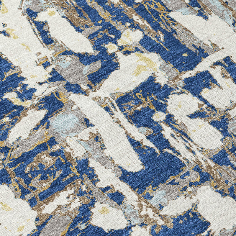 Close-up of abstract rug pattern in blue, cream, and light beige brushstrokes.