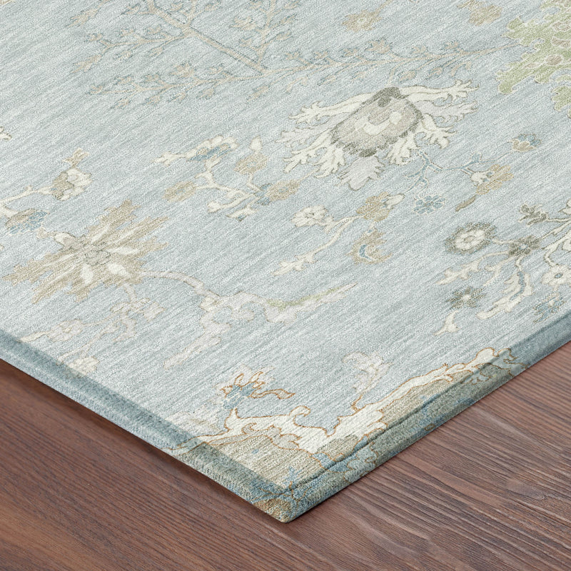 Corner detail of sky blue area rug with ivory scrolling floral pattern